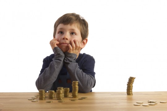 Boy sitting in front of money-towers