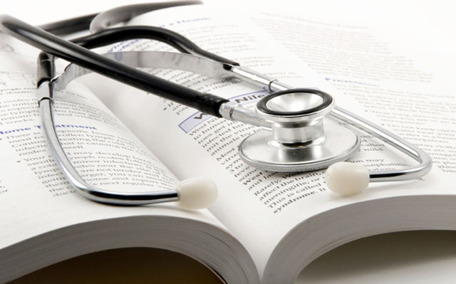 stethoscope on open book on a white background